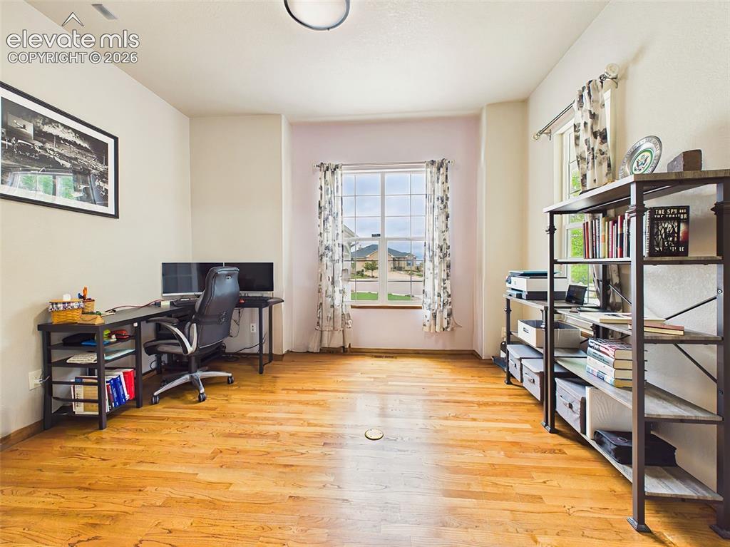 Image 24 of 50: Versatile office or flex space with hardwood flooring, abundant natural lig