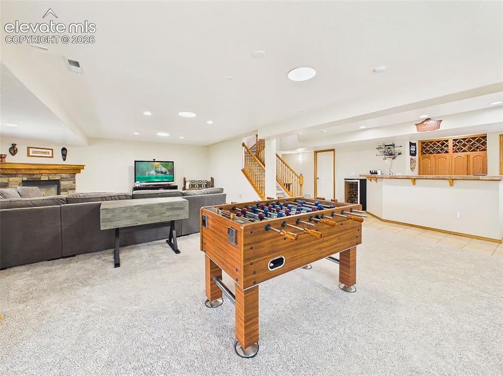Image 28 of 50: Expansive lower level with a dedicated game area, cozy fireplace seating, a