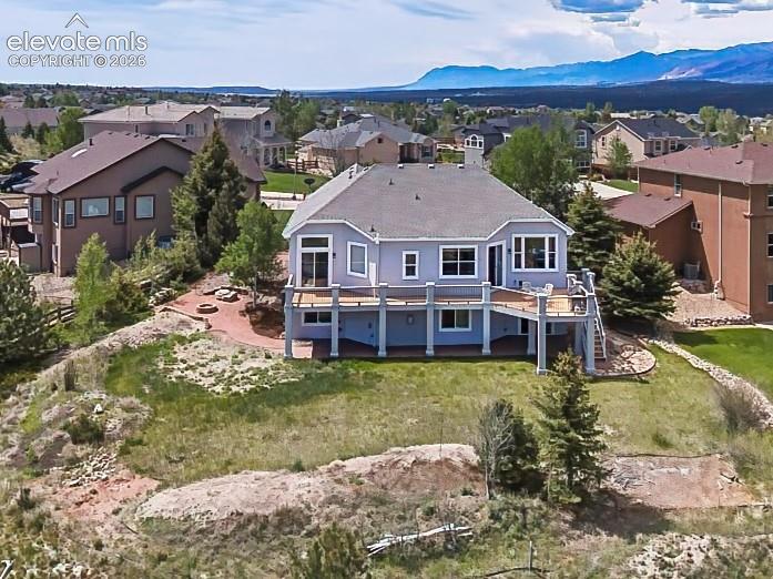 Image 38 of 50: Expansive backyard with a large elevated deck and open green space, perfect