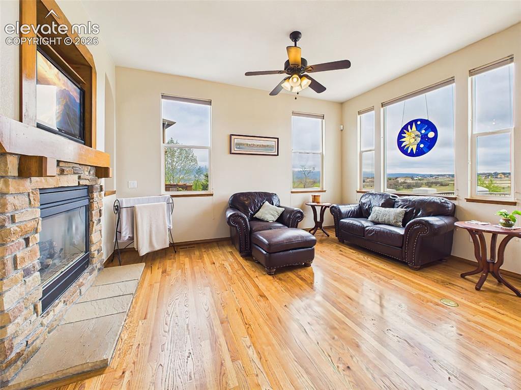 Image 7 of 50: Comfortable living room featuring a floor-to-ceiling stone fireplace, ceili