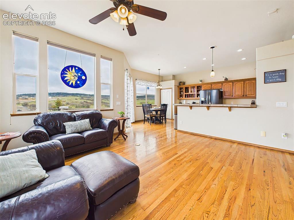 Image 9 of 50: Open-concept great room with soaring ceilings, hardwood floors, and large p