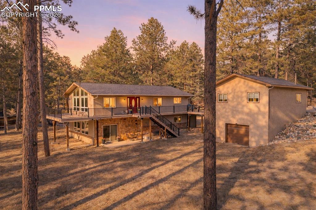 Caption: Back of house at dusk on .94 acre treed lot
