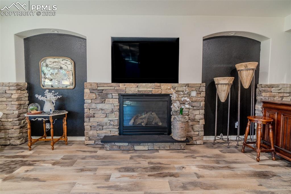 Image 25 of 50: Living room with wood finished floors and a gas fireplace