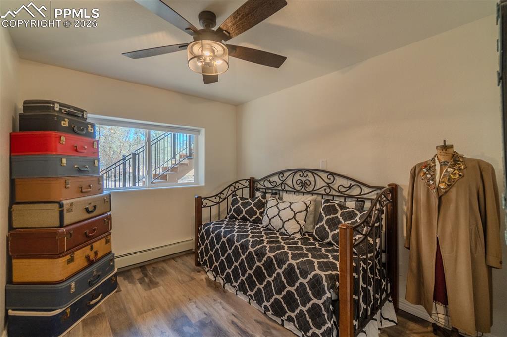 Image 28 of 50: 3rd Lower level Bedroom with baseboard heating, wood finished floors, and a