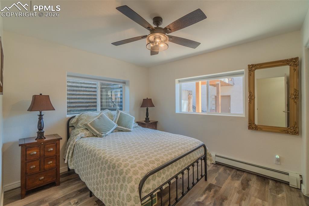 Image 29 of 50: 4th Lower Level Bedroom with a baseboard heating unit, dark wood-style floo
