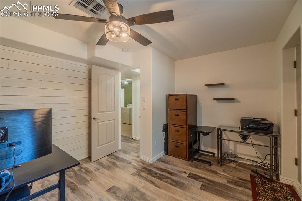 Image 34 of 50: 5th lower level bedroom wood finished floors, washer / clothes dryer, and a