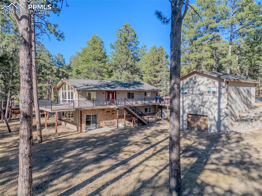Image 47 of 50: Rear view of property featuring an attached garage and stairs