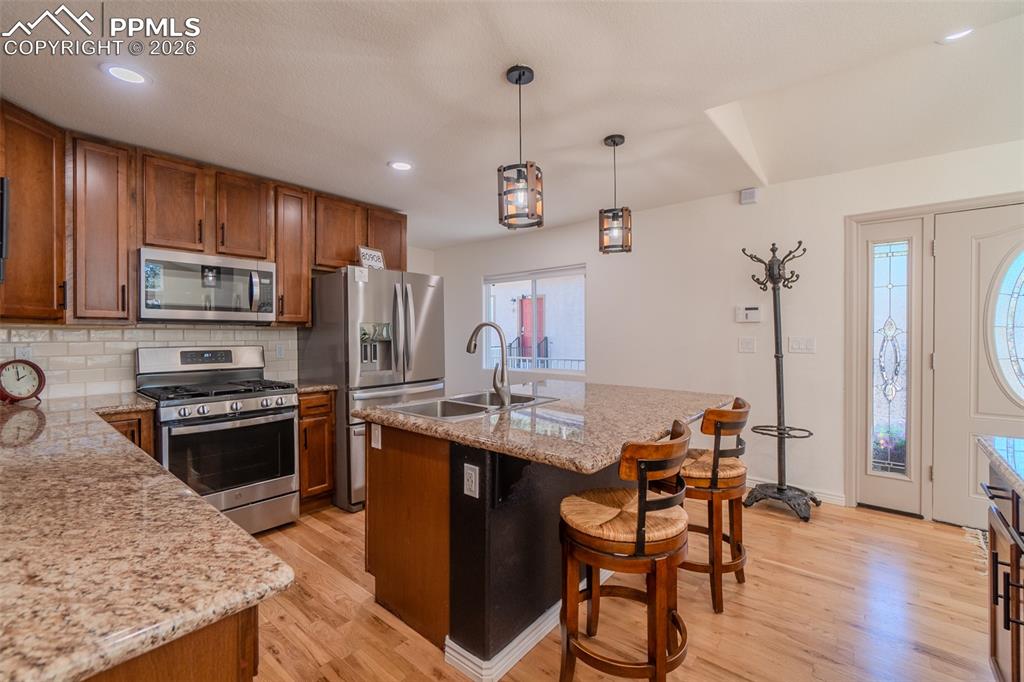Image 8 of 50: Kitchen featuring stainless steel appliances, wood finish cabinets, a kitch
