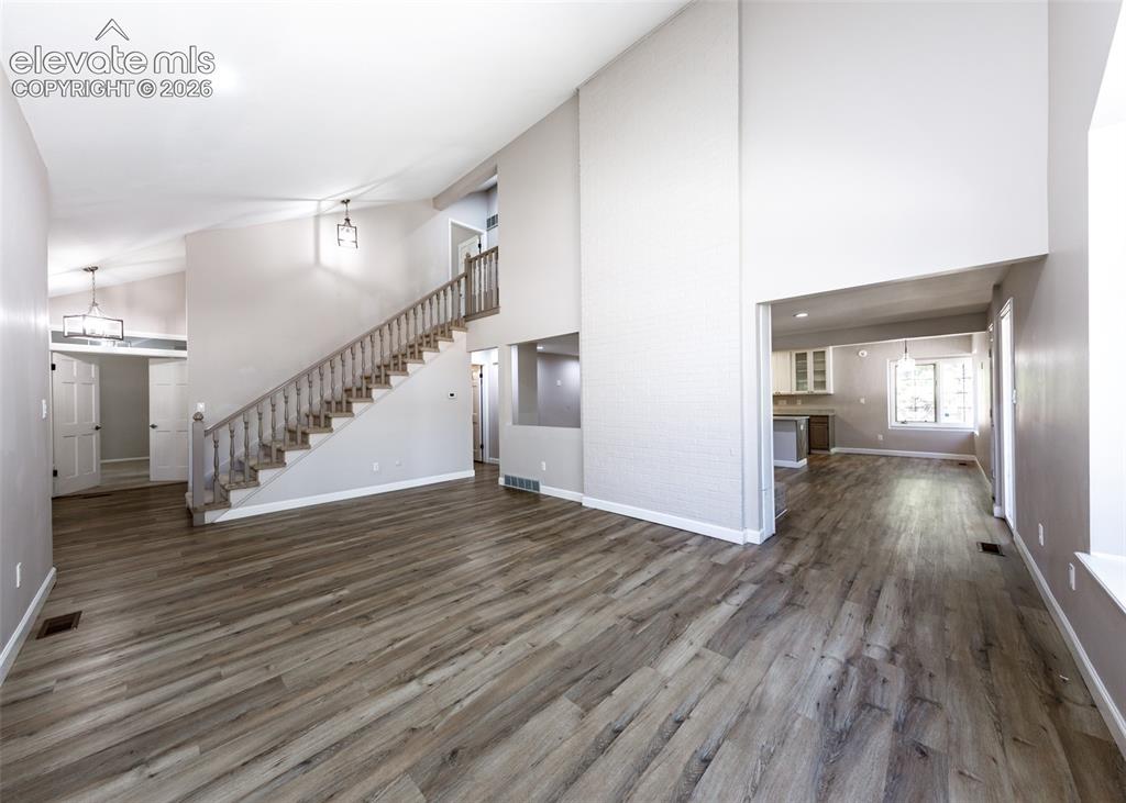 Image 11 of 44: Vaulted ceilings with recessed lighting, wood-finish flooring, a prominent 