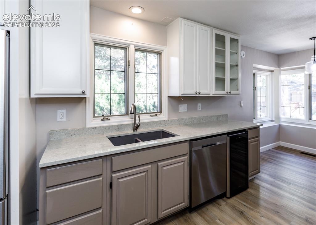 Image 23 of 44: Kitchen featuring white upper cabinetry, grey lower cabinetry, light-colore