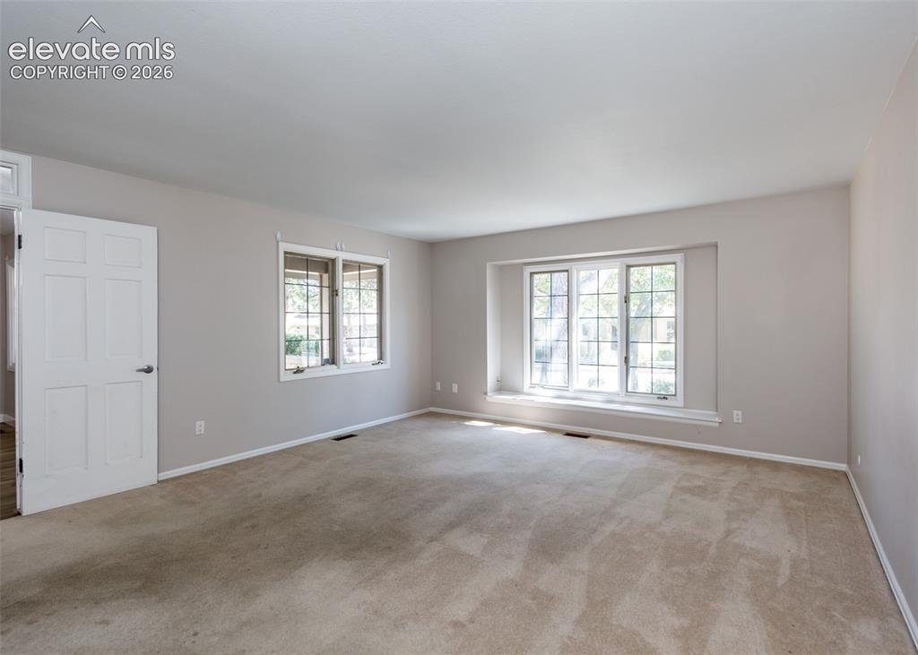Image 24 of 44: Expansive room featuring carpet flooring, painted walls, and multiple windo