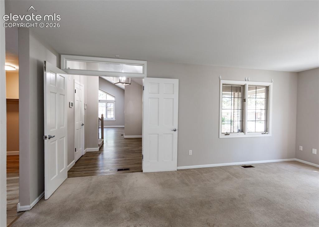 Image 25 of 44: Carpeted room featuring a window with grid pattern and light gray wall pain