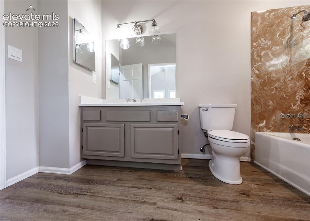 Image 35 of 50: Wood-finish flooring, single vanity with shaker-style cabinetry, white coun