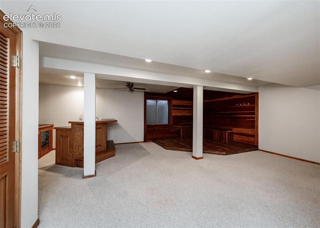 Image 39 of 44: Recessed lighting throughout, wood-finish bar with built-in sink, wood-pane