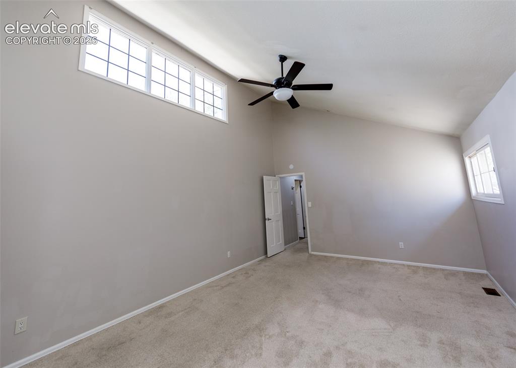 Image 39 of 50: Vaulted ceilings, transom windows, neutral wall tones, carpet flooring, and