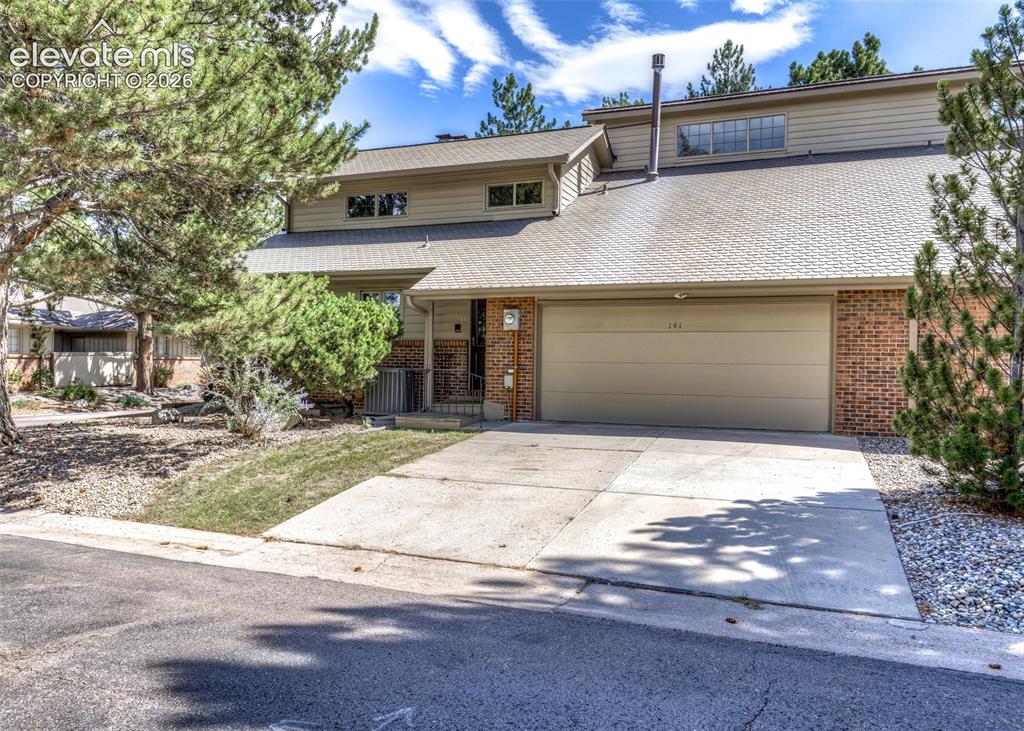 Image 4 of 44: Two-story residence featuring a two-car garage, brick and siding exterior,