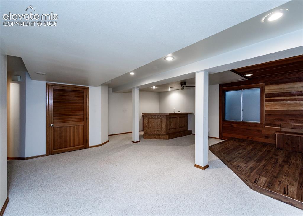 Image 40 of 44: Finished lower level featuring recessed lighting, a built-in wet bar, wood-