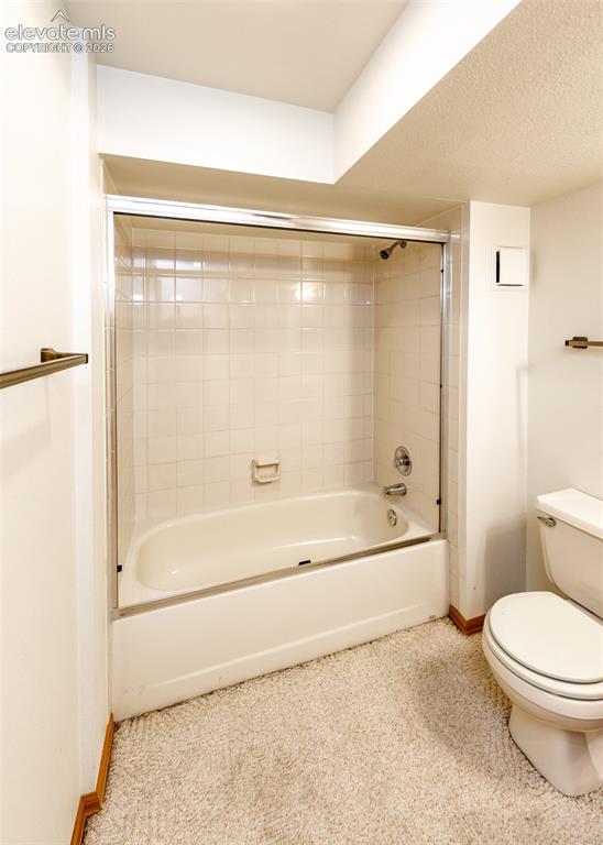 Image 49 of 50: Tub and shower combination with glass enclosure and tiled surround
