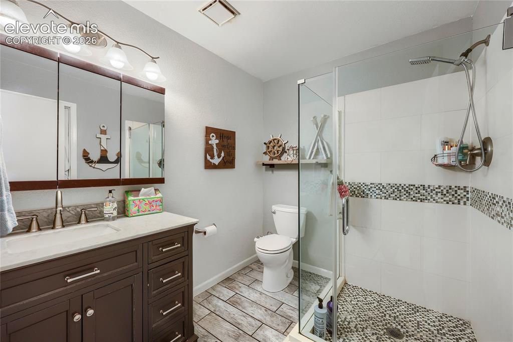 Image 15 of 19: Dark wood-finish vanity with an integrated basin, triple medicine cabinet,