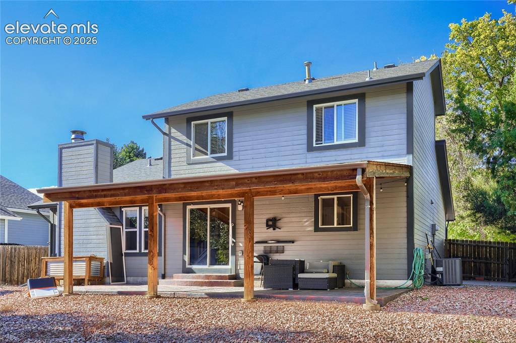 Image 17 of 19: Two-story property featuring gray siding, a covered patio with wood beams,