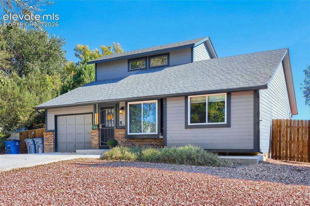 Image 2 of 19: Siding exterior with brick accents, attached garage, and asphalt shingle ro