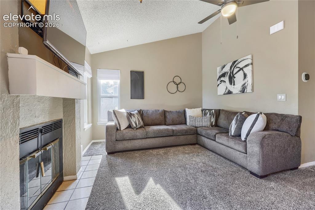Image 7 of 19: Vaulted ceilings with a ceiling fan, wall-mounted display, built-in firepla