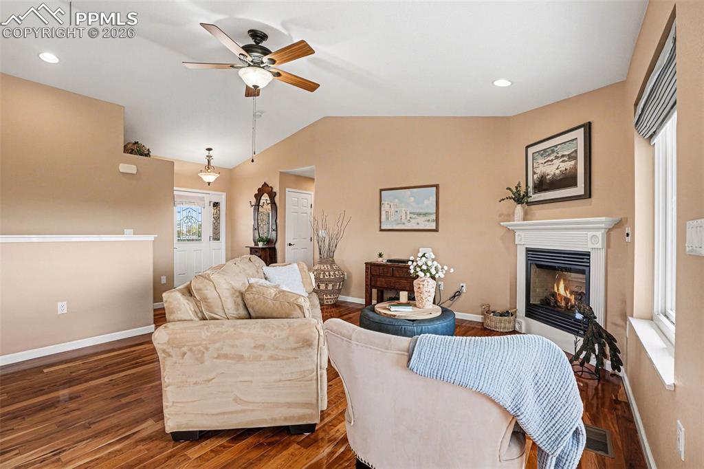 Image 10 of 47: The living room features vaulted ceilings and beautiful cherry hardwood flo