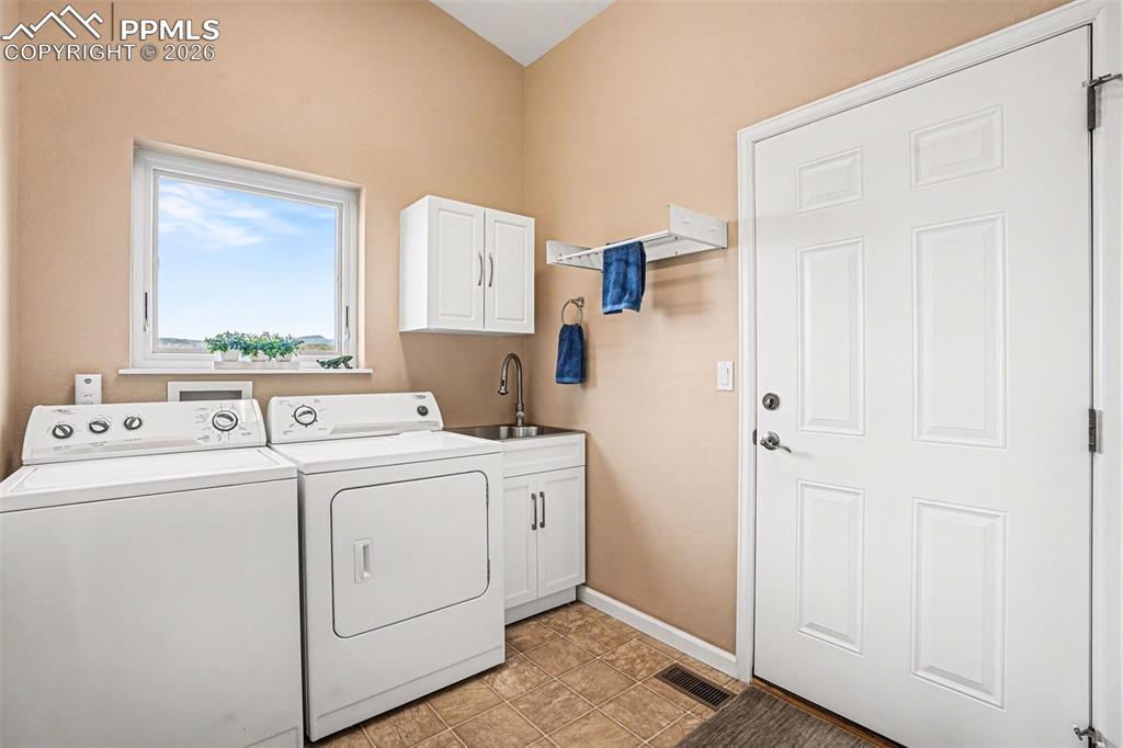 Image 18 of 47: The laundry room is well-appointed and functional, featuring a stainless st