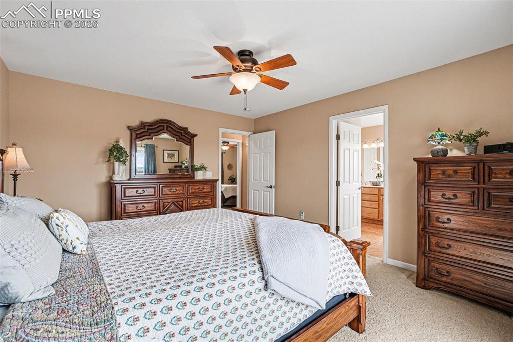 Image 20 of 47: The primary suite features soft carpet flooring with a walk out to a deck a