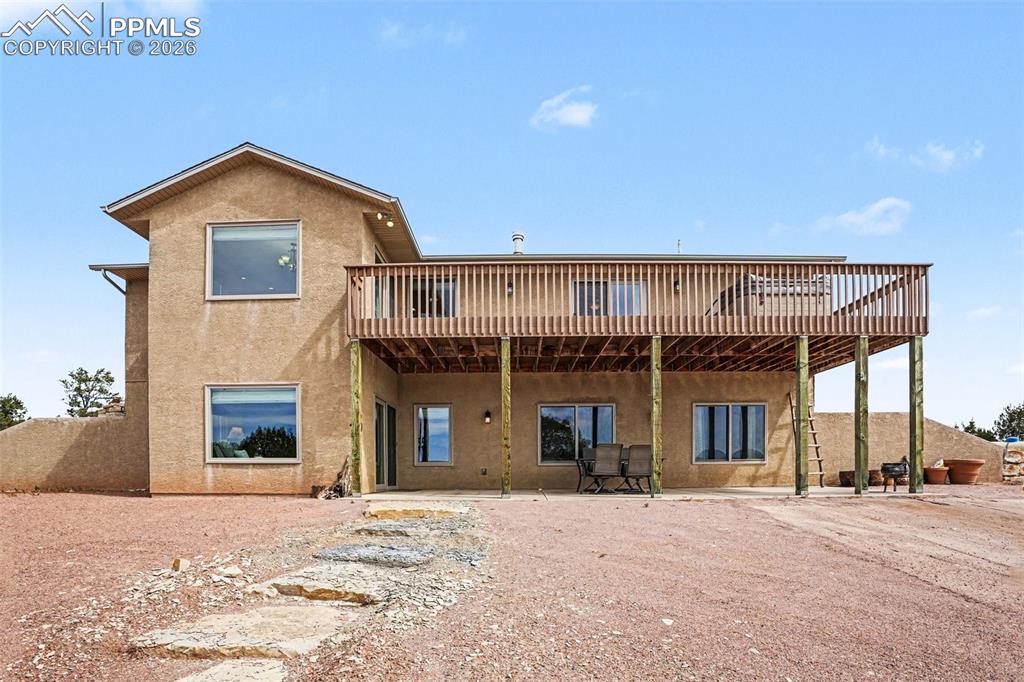 Image 35 of 47: The back of the home features a walk-out basement with access to a concrete