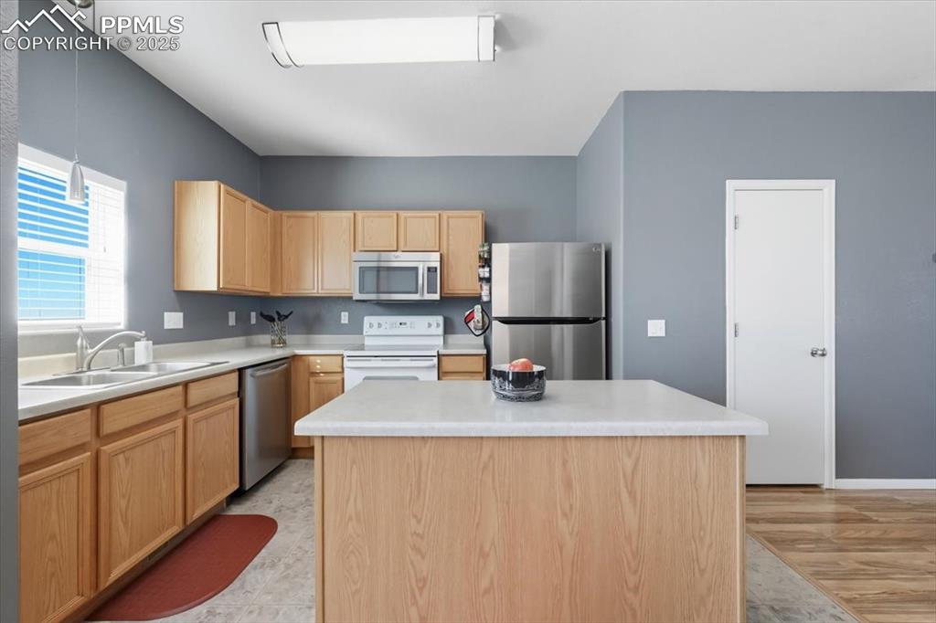 Image 10 of 36: Kitchen featuring light brown cabinetry, appliances with stainless steel fi
