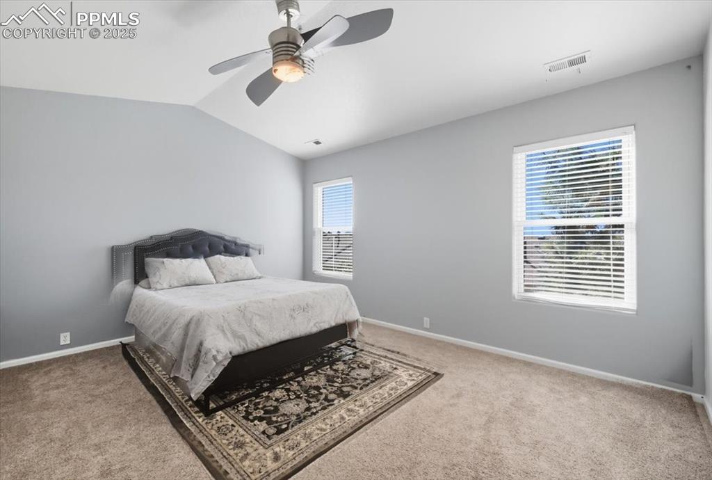 Image 16 of 36: Carpeted bedroom featuring vaulted ceiling and ceiling fan
