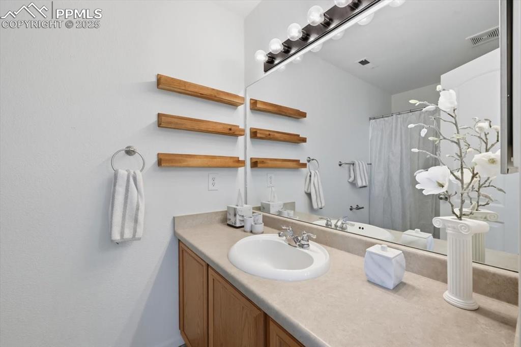 Image 19 of 36: Bathroom featuring vanity and a shower with shower curtain
