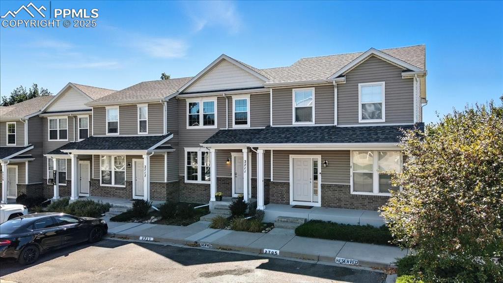 Image 2 of 36: Craftsman-style home featuring brick siding, uncovered parking, a shingled