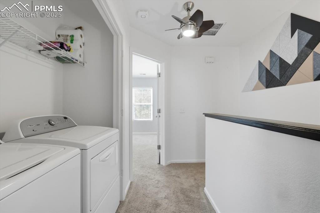 Image 21 of 36: Washroom featuring light carpet, washer and clothes dryer, and ceiling fan