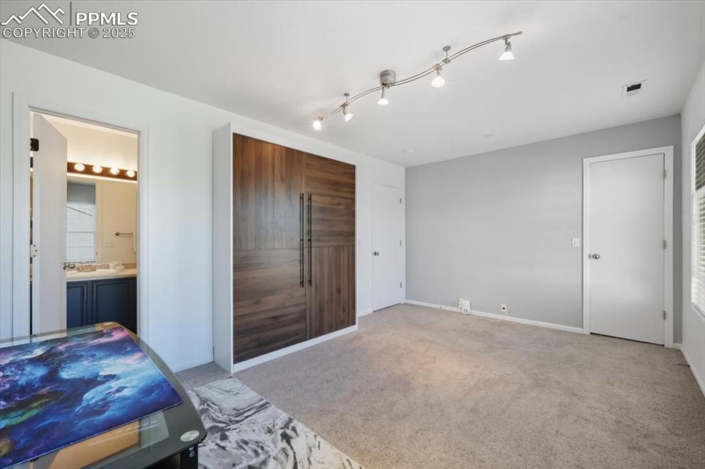 Image 24 of 36: Bedroom with an accent wall and carpet