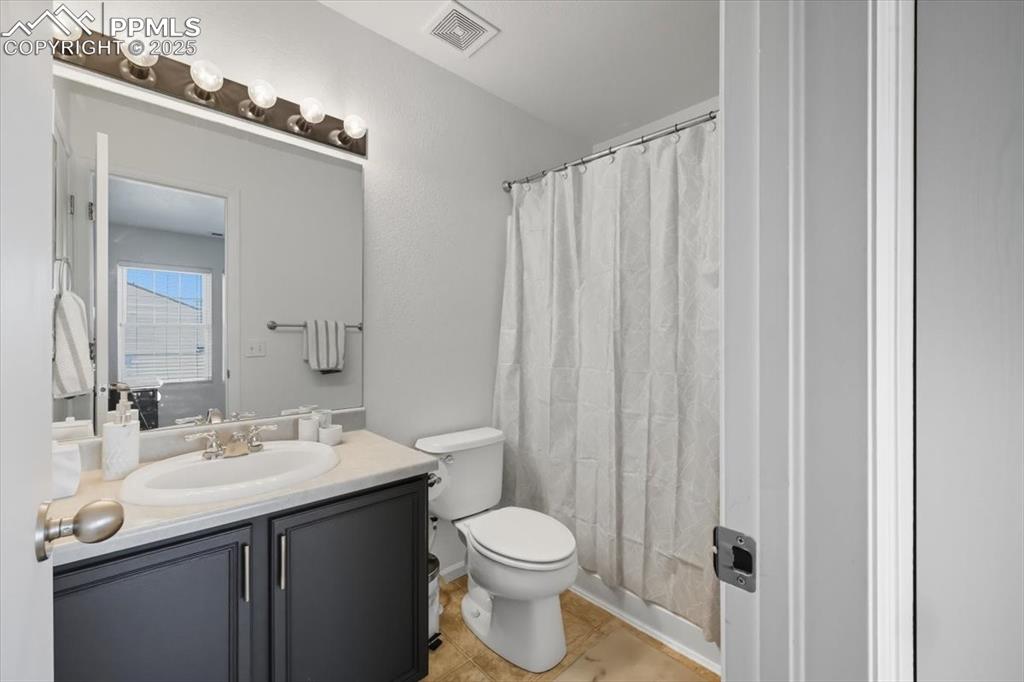 Image 26 of 36: Bathroom with vanity and light tile patterned flooring
