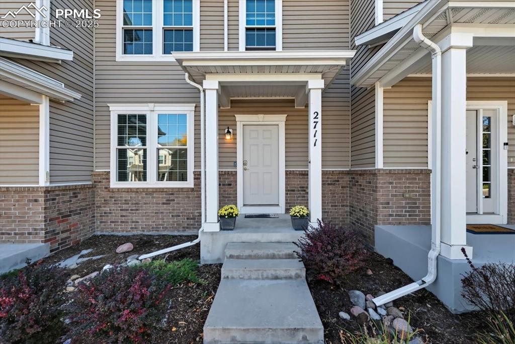 Image 3 of 36: Doorway to property with brick siding