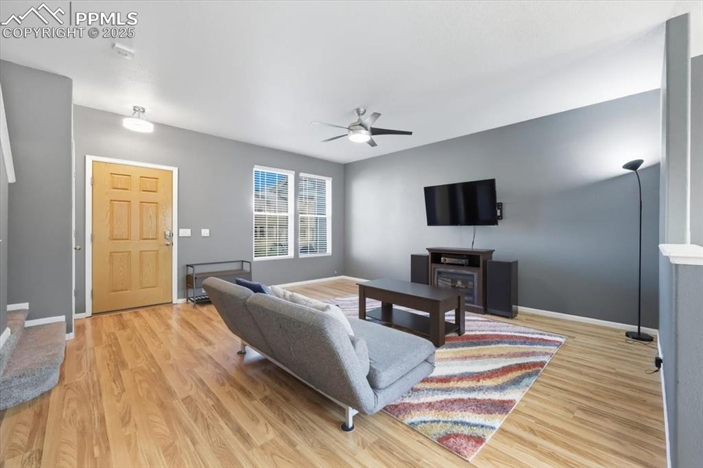 Image 6 of 36: Living room featuring light wood-style flooring and a ceiling fan