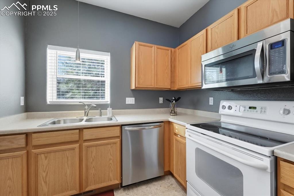Image 8 of 36: Kitchen featuring stainless steel appliances, light brown cabinets, light c
