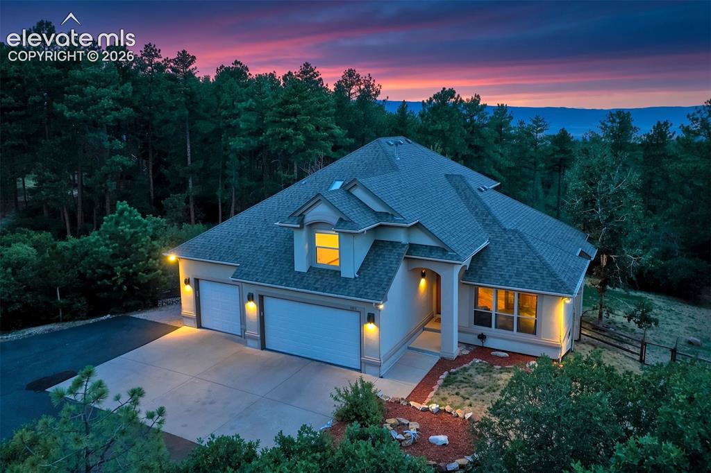 Caption: Stucco exterior with multiple gables and a three-car garage
