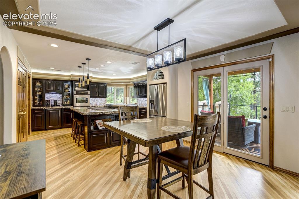 Image 11 of 40: Hardwood-style flooring, tray ceiling with recessed lighting, black cabinet