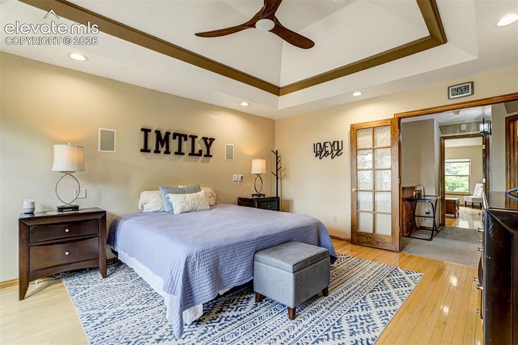 Image 19 of 40: Tray ceiling with recessed lighting and a ceiling fan, light wood-finish fl