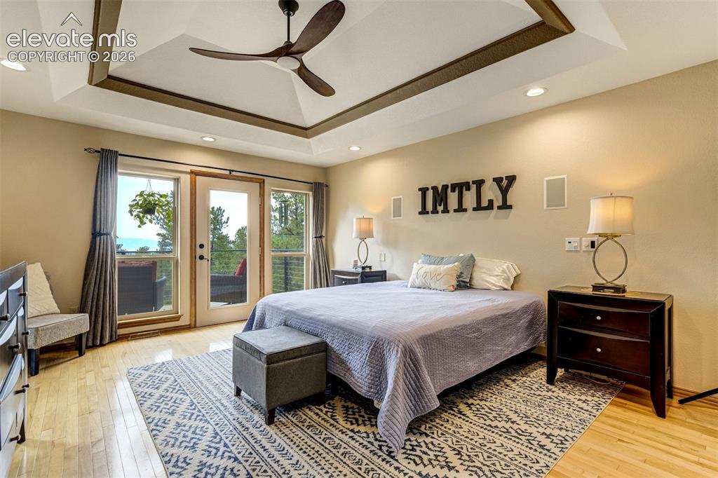 Image 20 of 40: Tray ceiling with recessed lighting and a ceiling fan, hardwood flooring, a