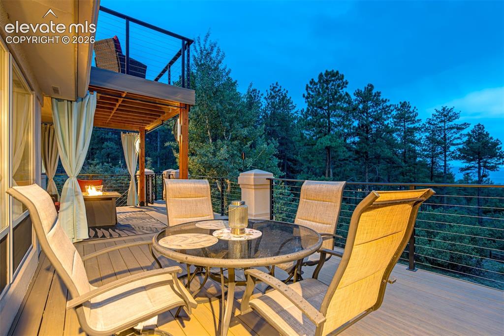 Image 36 of 40: Expansive outdoor deck featuring wood-finish flooring, cable railing, and a