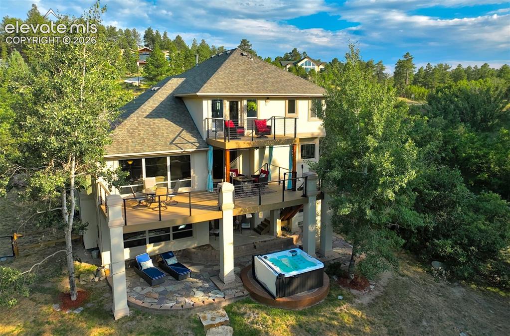 Image 39 of 40: Multi-level exterior with two elevated decks, a ground-level patio, and an 