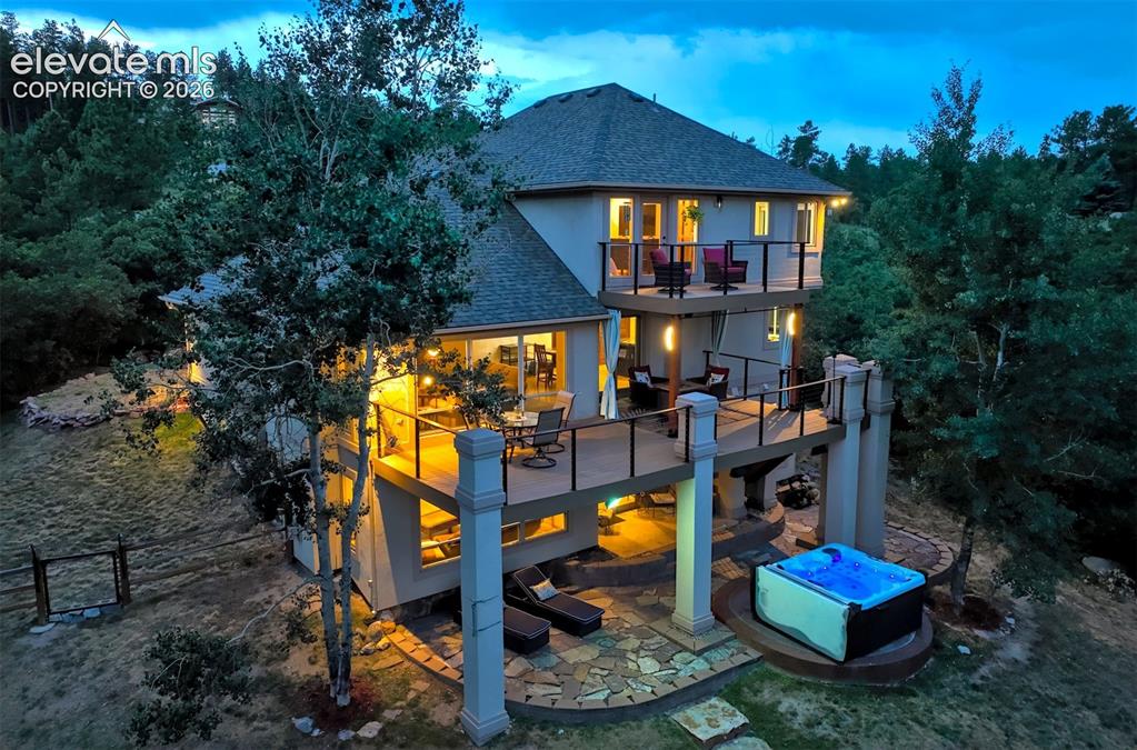 Image 5 of 40: Multi-level exterior with a prominent upper balcony and a lower deck with g