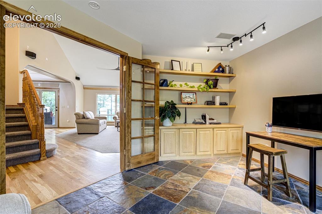 Image 8 of 40: Slate tile flooring, custom built-in cabinetry, floating wood shelving, tra
