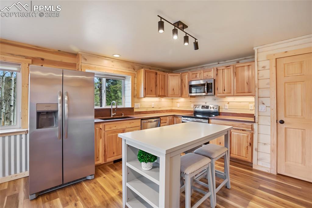 Image 14 of 45: Kitchen with appliances with stainless steel finishes, a sink, open shelves