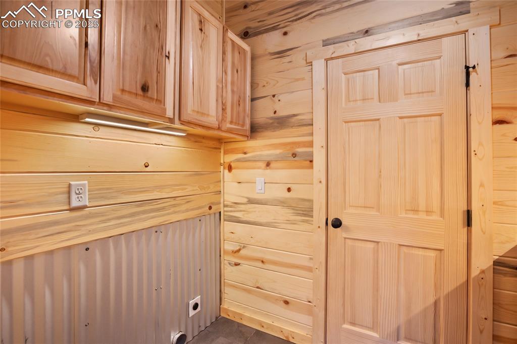 Image 29 of 45: Laundry area featuring cabinet space, hookup for an electric dryer, and woo